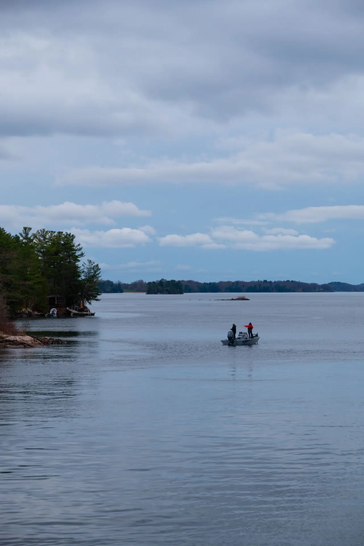 A small aluminium fishing boat on a calm Ontario lake