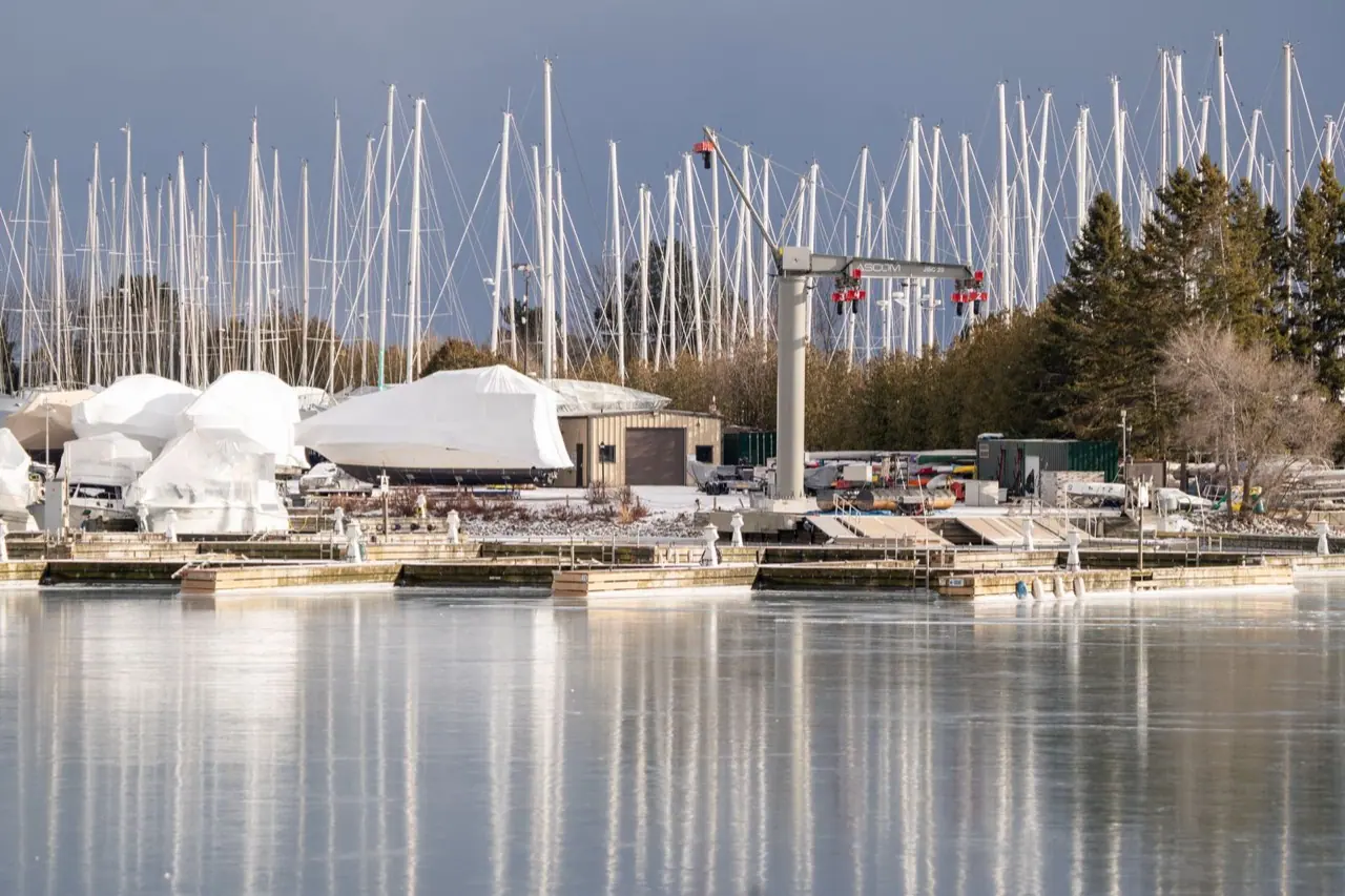 Boats shrink-wrapped in white for winter, sitting on the hard at a Toronto marina